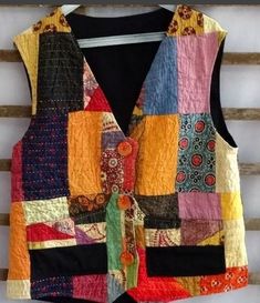 a multicolored vest hanging on a wooden wall