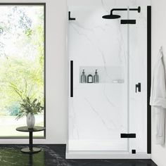 a white bathroom with black accents and marble flooring, along with a glass shower door