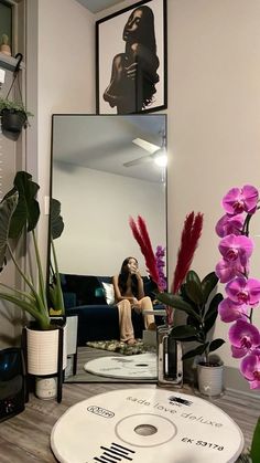 a woman taking a selfie in front of a mirror with flowers on the table