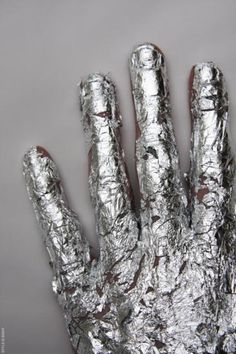 a person's hand covered in tin foil