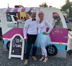 a man and woman standing in front of a ice cream truck at an outdoor event