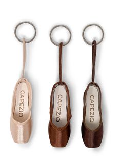 three pairs of shoes hanging from metal hooks on a white background with the caption capezio