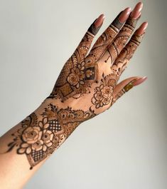 a woman's hand with henna tattoos on it