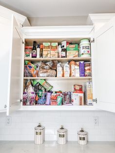 an open cabinet in the kitchen filled with food