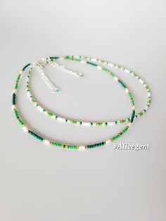 three strands of green and white beaded necklaces on a white background with the words,