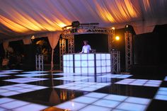 a man sitting at a bar on top of a checkered floor in front of an audience