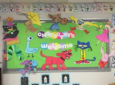 a bulletin board with children's welcome signs and pictures on the wall above it