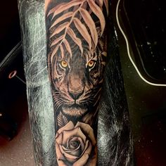 a tiger with a rose tattoo on his arm is shown in black and grey colors