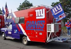 two giants trucks are parked on the side of the road with people standing around them