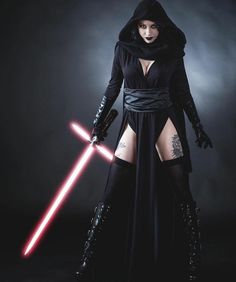 a woman dressed as darth vader holding two lightsabes