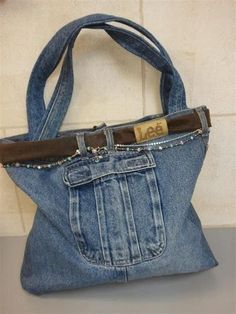 a purse made out of old jeans is sitting on a counter top with the bottom pocket open