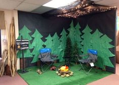 an office decorated for the holidays with chairs and campfires in front of trees