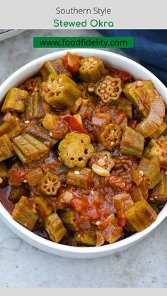 a white bowl filled with cooked okra next to a blue napkin and fork on the side