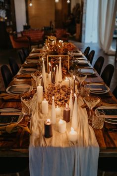 a long table with candles and plates on it