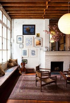 a living room filled with lots of furniture and pictures on the wall above it's fireplace