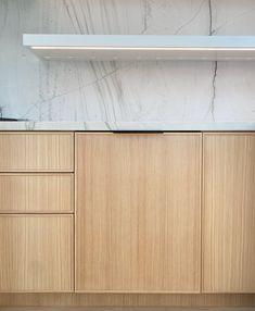 an empty kitchen with wooden cabinets and marble counter tops on the wall behind it is a stove top oven