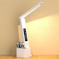 a desk lamp with multiple batteries in it on top of a wooden table next to a wall