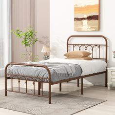 a metal bed frame in a bedroom with a rug on the floor and a painting above it