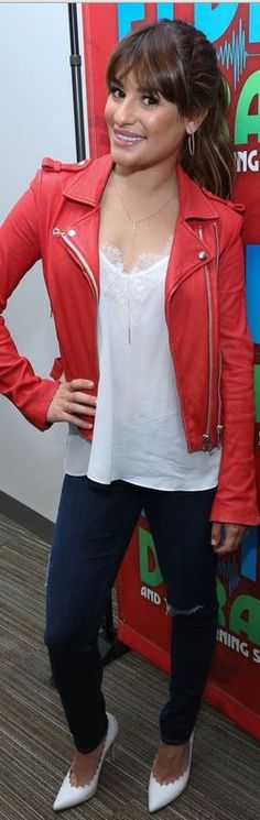 a woman standing in front of a red wall