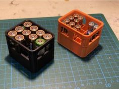 two plastic containers filled with batteries sitting on top of a cutting board