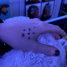 a person with a small star tattoo on their left hand