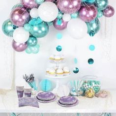 a table topped with lots of balloons and desserts