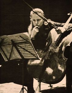 an old photo of a woman playing the cello