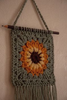 a crocheted wall hanging with a flower on it