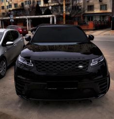 two cars parked next to each other in a parking lot