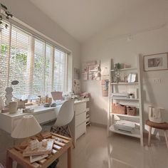 a room with white furniture and lots of shelves on the wall next to a window