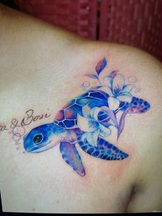 a woman's chest with a tattoo on it that has a turtle and flowers