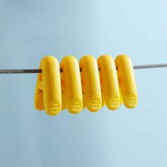 several yellow objects hanging on a wire