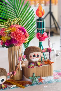 two stuffed animals sitting next to each other on a table with flowers and candles in the background