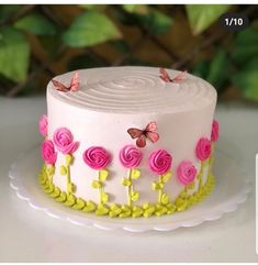 a white cake with pink flowers and butterflies on it