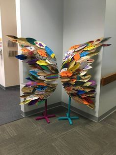 an art piece made out of magazines sitting on top of a blue stand in front of a wall