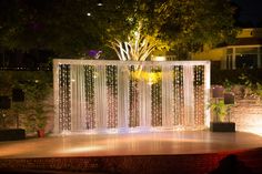 an outdoor stage set up with lights and curtains