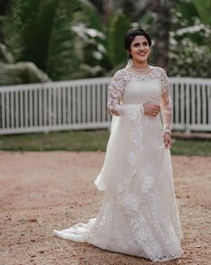 a woman in a wedding dress posing for the camera with her hand on her hip