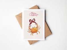 a card with a crab wearing a red bow on it's head and the words merry christmas