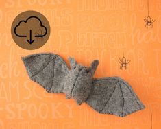 a felt bat is laying on an orange background