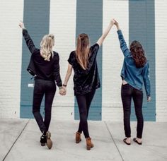 three women standing in front of a blue and white wall with the word snap on it