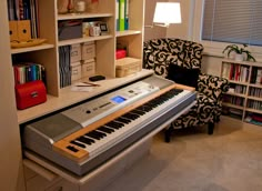 an electronic keyboard sitting on top of a desk in front of a book shelf filled with books