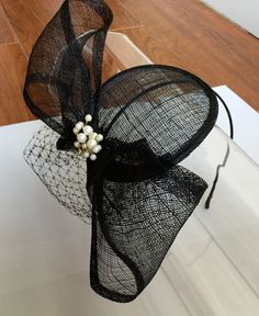 This Black Large Pearl Bow Sinamay Fascinator Hat with Veil and Satin Headband is a beautiful accessory for weddings, parties, cocktail, evening, and other special occasions. It is elegant, delicate, stylish, and super chic! Will definitely add a special touch to your outfit!! I only accept PayPal and ship all orders within 24 hours via USPS. Feel free to send me a convo with any questions. Thank you for visiting Hettie Hair Accessories! Fascinator Hats Diy, Hat With Veil, Tea Hats, Sinamay Fascinator, Veiled Hats, Ladies Hats, Black Fascinator, Sinamay Hats, Couture Hats