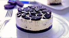 an oreo cookie cheesecake on a plate with purple cookies around the edges and white frosting