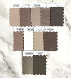 four swatches of different shades of grey and brown on a white marble countertop