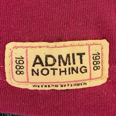 a label on the back of a red shirt that says admit nothing written in black