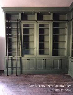 an empty room with green bookcases and shelves