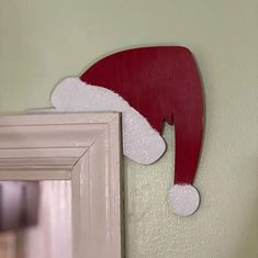 a red and white santa hat hanging on the wall