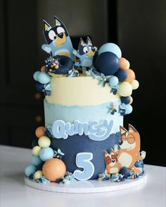 a cake decorated with cartoon characters and balloons