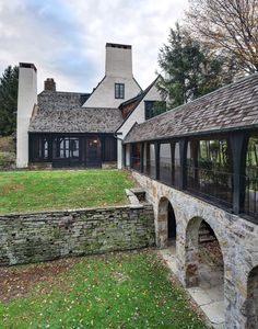 an old stone house with a green lawn