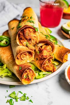 several burritos stacked on top of each other on a plate next to salsa